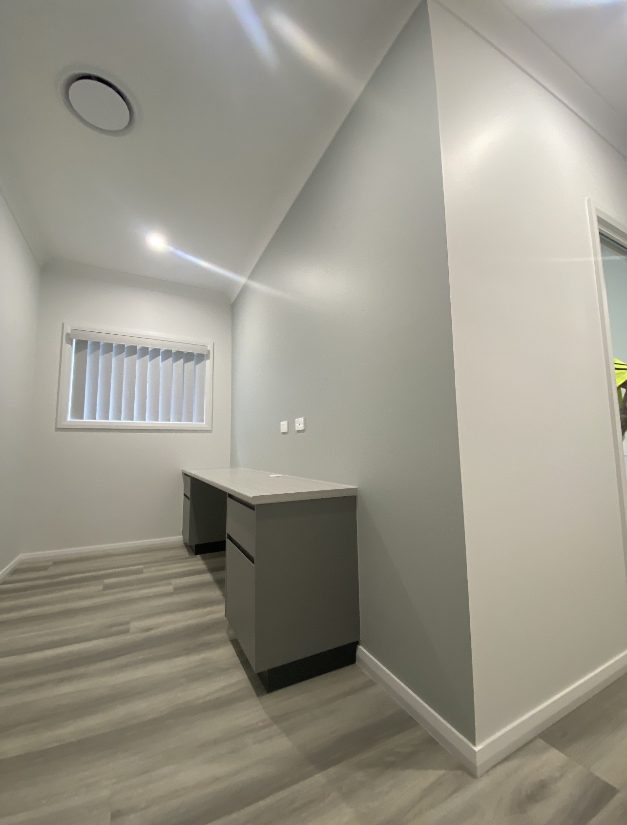Interior study nook with soft grey walls and crisp white ceiling