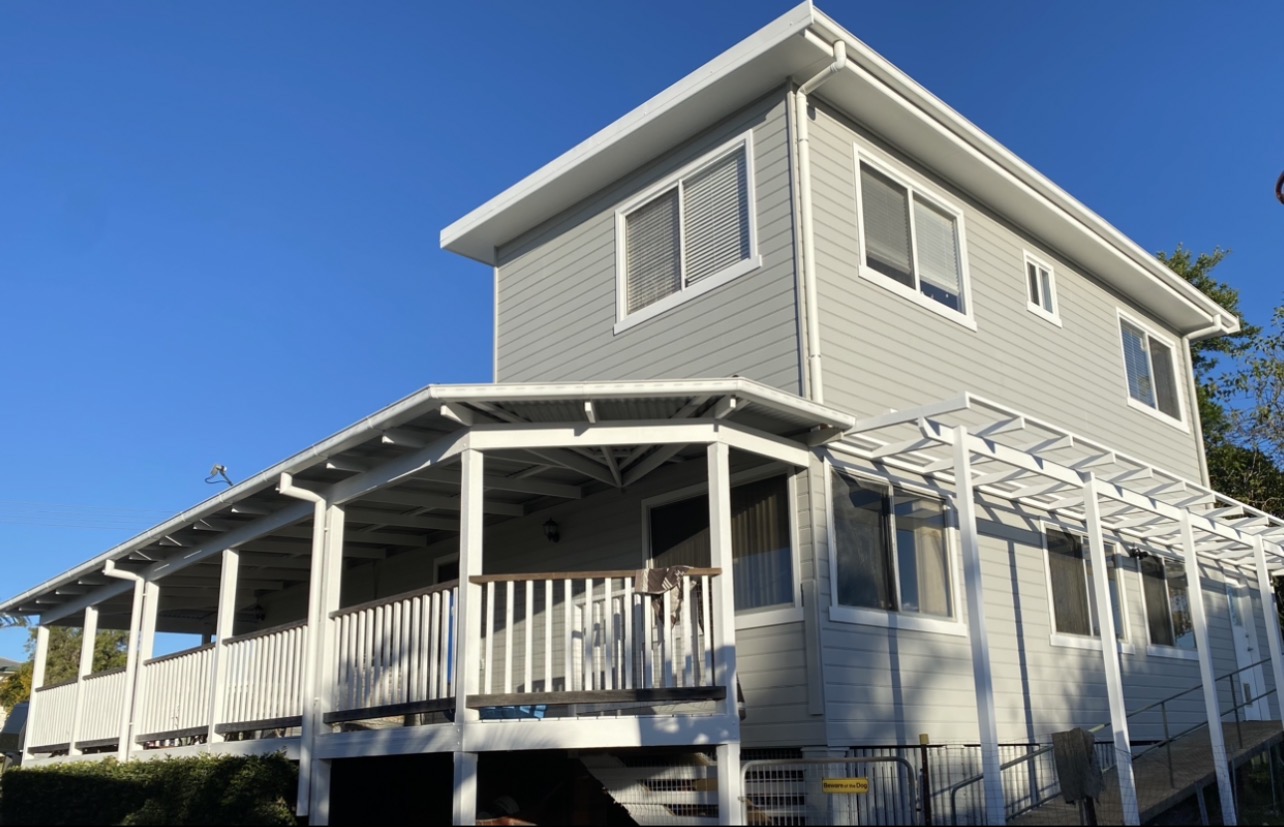 Two-storey weatherboard home with freshly painted grey exterior and white trims