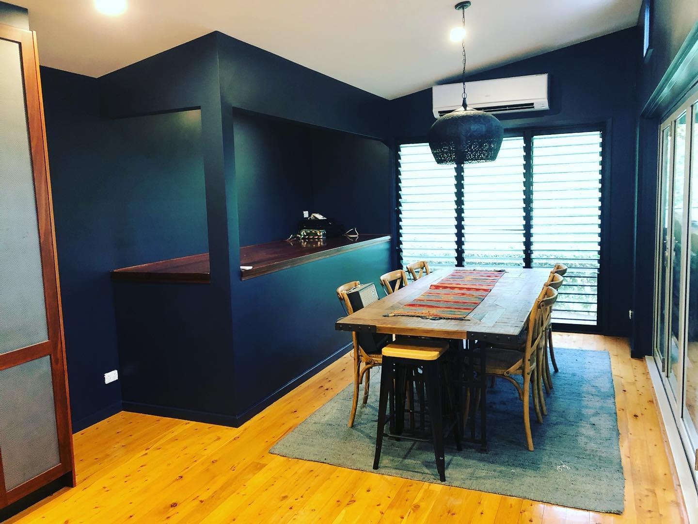 Interior dining area with deep navy feature walls and crisp paint finish